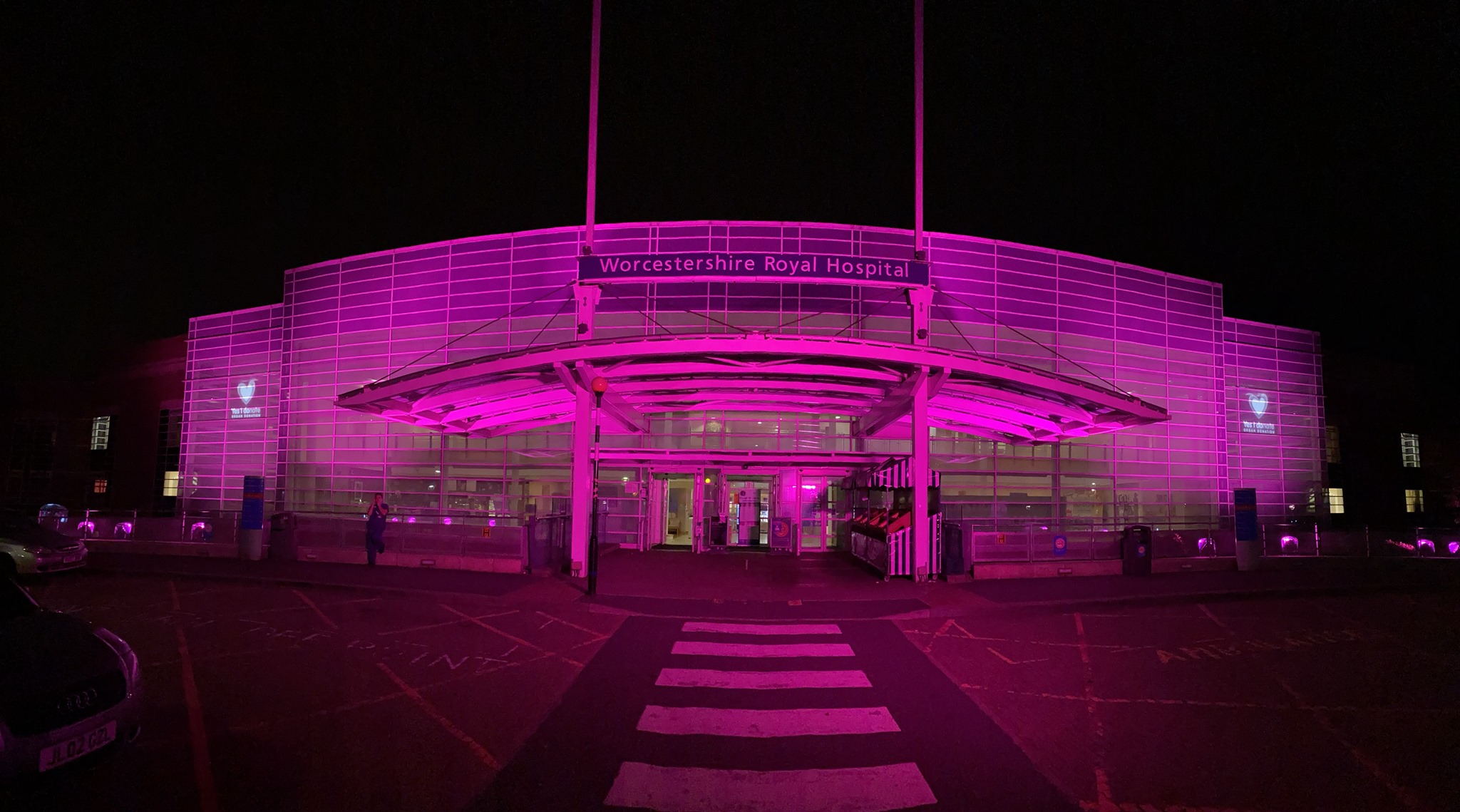 Worcestershire Royal Hospital lit up at night with pink lights