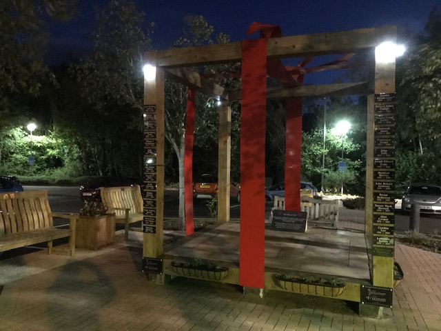 Memorial sculpture and benches at night time