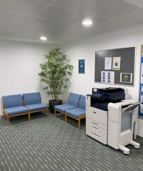 Image of the area outside of room 2, showing soft seating and MFD (Printer).