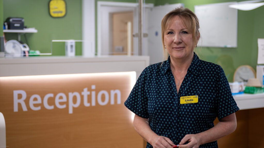 A clerk stood in front of a hospital reception desk