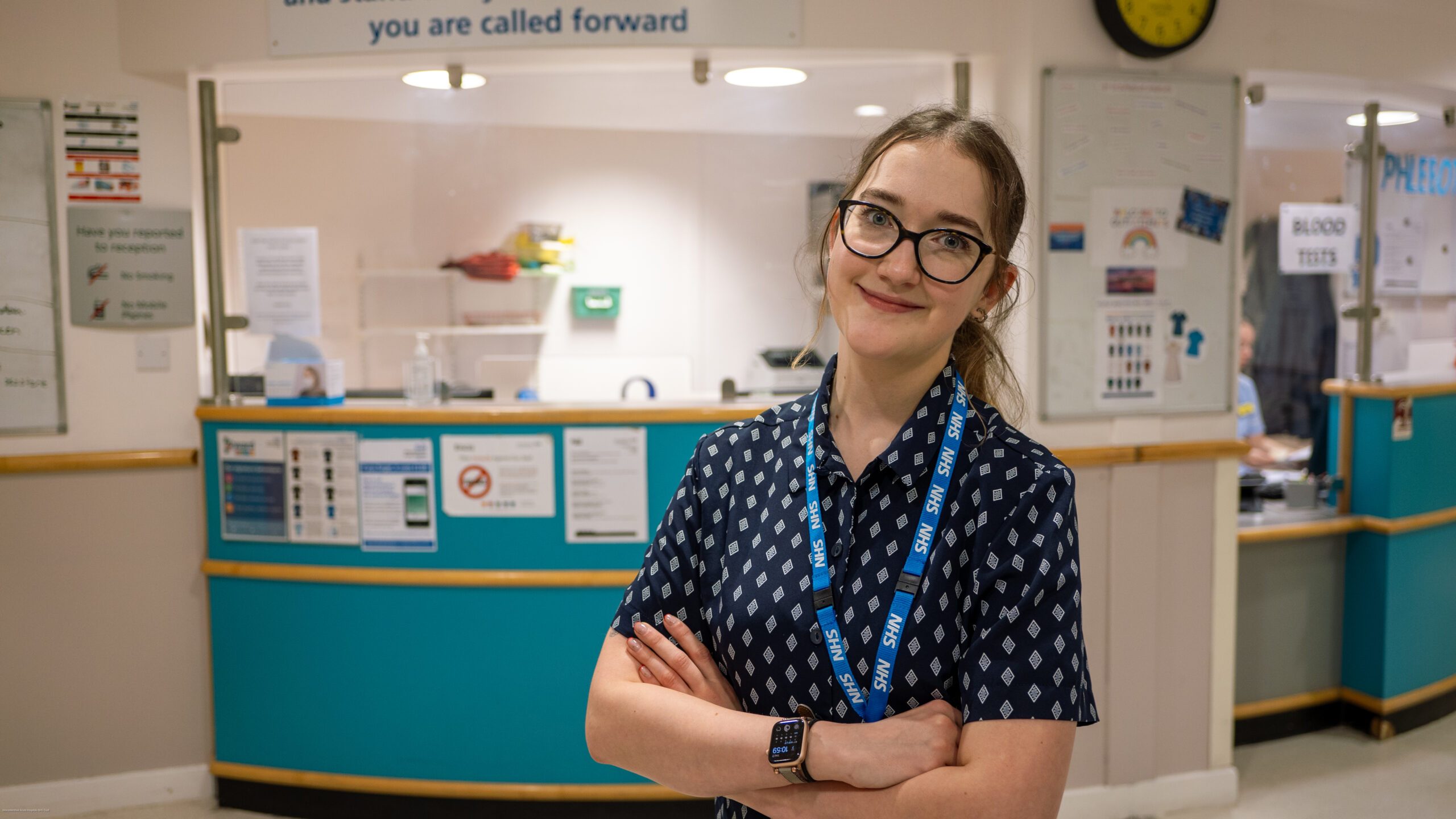 A clerk stood in front of a hospital reception desk