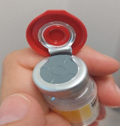 Vial of medicine with top flipped open exposing rubber bung