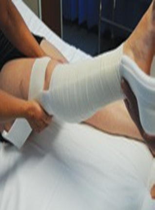Person having right leg bandaged in preparation for skin traction