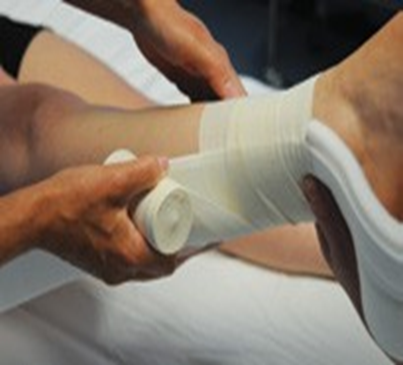 Person having right leg bandaged in preparation for skin traction