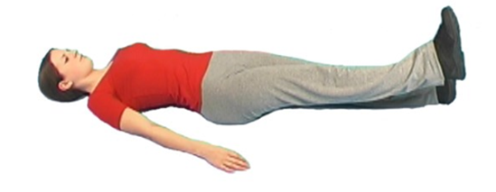 Person lay flat on ground with straight legs one raised slightly in the air