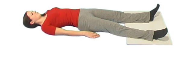 Person lying flat on the ground with feet shoulder width apart