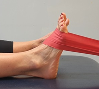 Foot hooked in exercise band moving back and forth