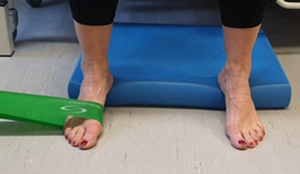 Foot hooked in exercise band so it can be moved to side to stretch the band