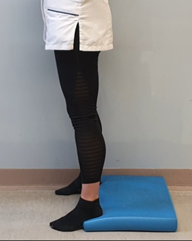 Standing with heels raised on a mat or book