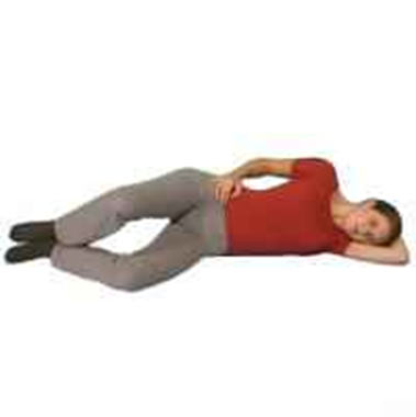Person lay on side head resting on arm knees slightly bent heels in line with spine. Top knee is rotated and opened upwards heels stay together