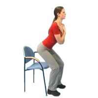 Person standing from chair with arms crossed in front of body
