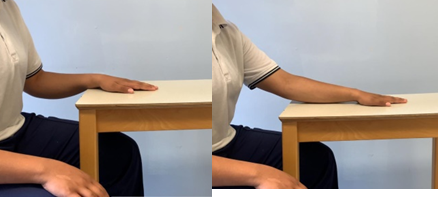 Image of hand face down on table being slid out and back (using a towel)