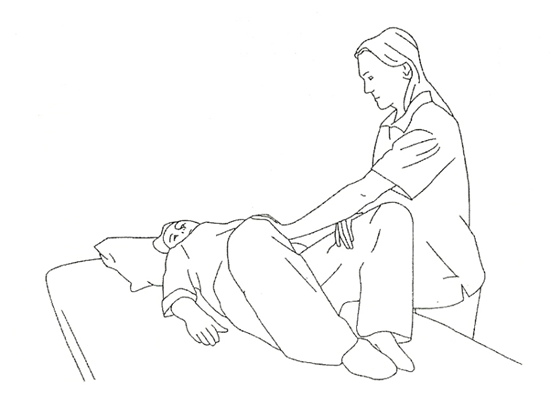 A diagram of a helper aiding an individual lay flat on the ground with feet facing each other and knees bent and dropped out to each side. Helper is assisting with knees