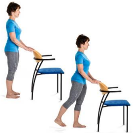 Person holding back of chair standing tall and raising leg straight backwards. 