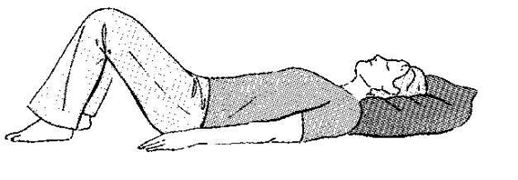 An individual lay flat on back with head supported on a pillow and knees bent, feet are flat on floor or surface