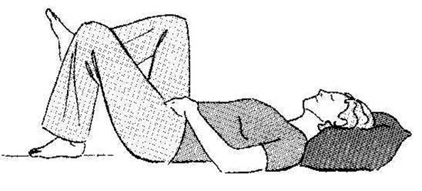 An individual lay flat on back with head supported on a pillow and knees bent, feet are flat on floor or surface. One bent leg is lifted in the air