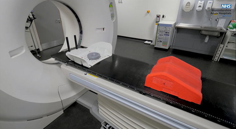 An image of the scanner bed with some equipment that the Radiologists use to help people remain still. Including a red knee support and a head positioning cradle