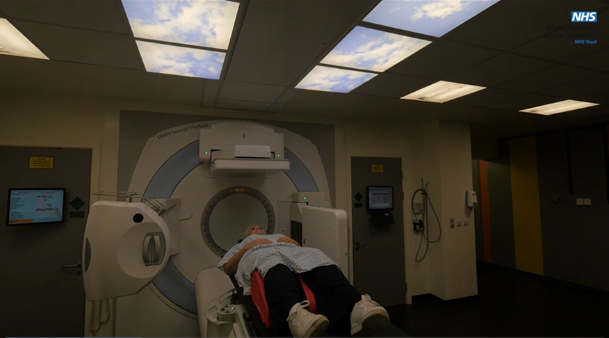 An image of the scanner and patient. The room has been made darker but safety lights remain