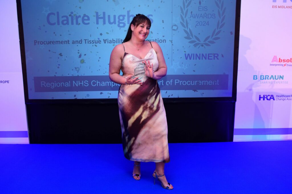 Claire holding her award on stage at the awards ceremony.
