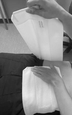 Image of abdominal binder being fixed into place at front of lower abdomen