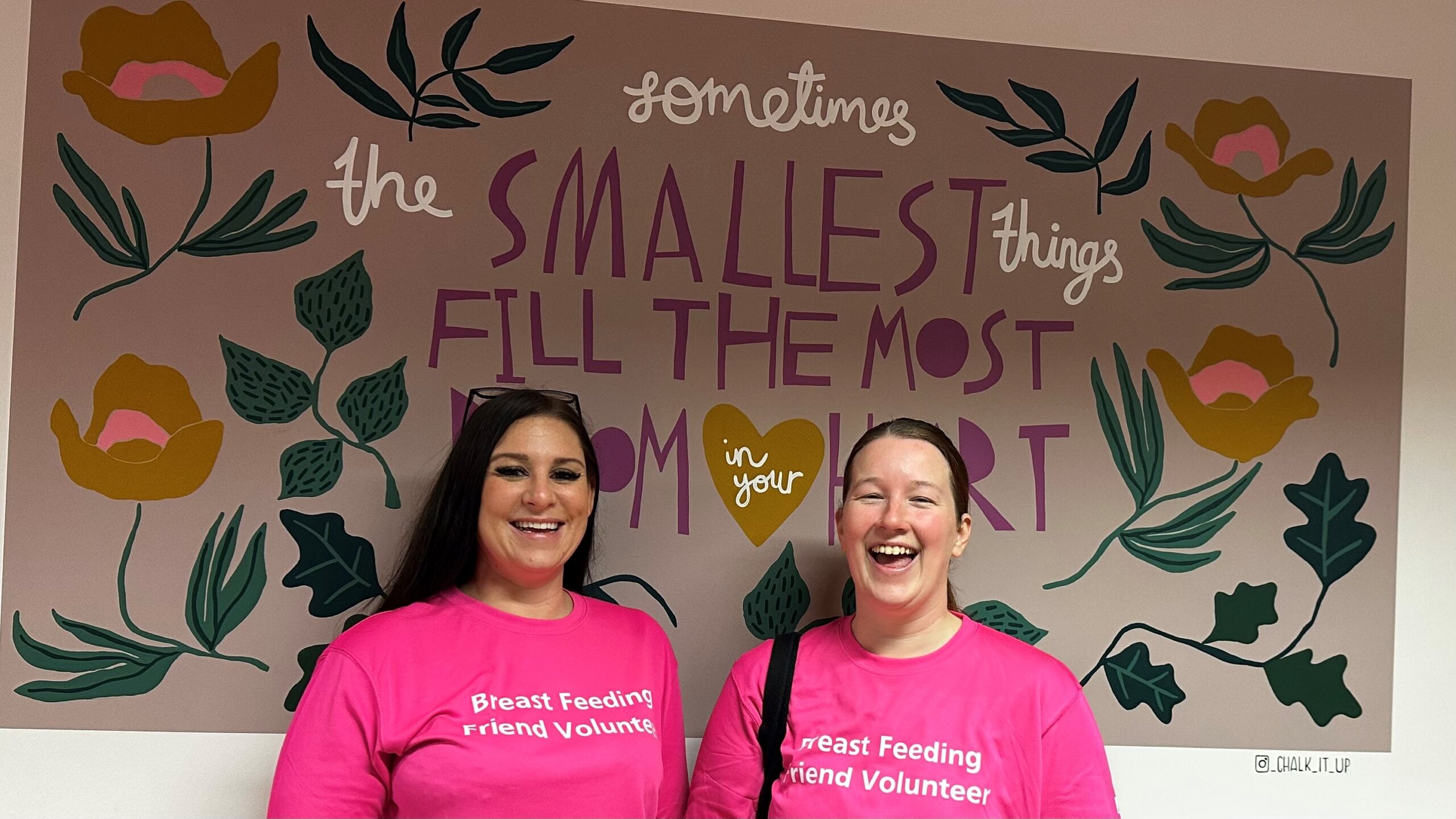 Two previous Breastfeeding Friend Volunteers in pink t-shirts on the Postnatal Ward at Worcestershire Royal Hospital.