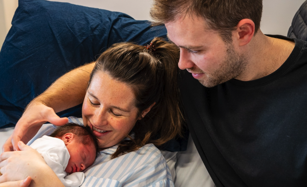 A mother and father holding their newborn child