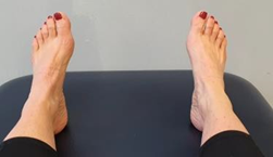 Feet with heels on bed toes pointing up