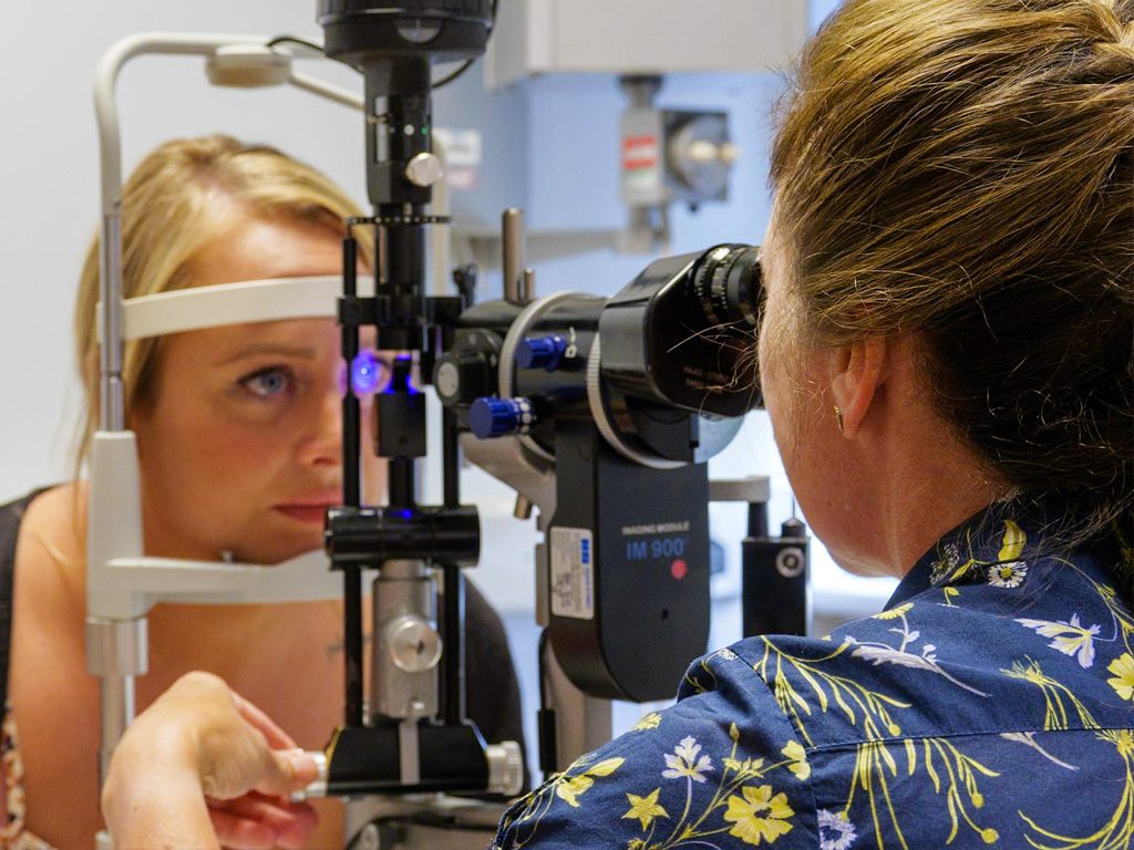 Photograph of a patient having an ophthalmology examination. Background in hospital setting.