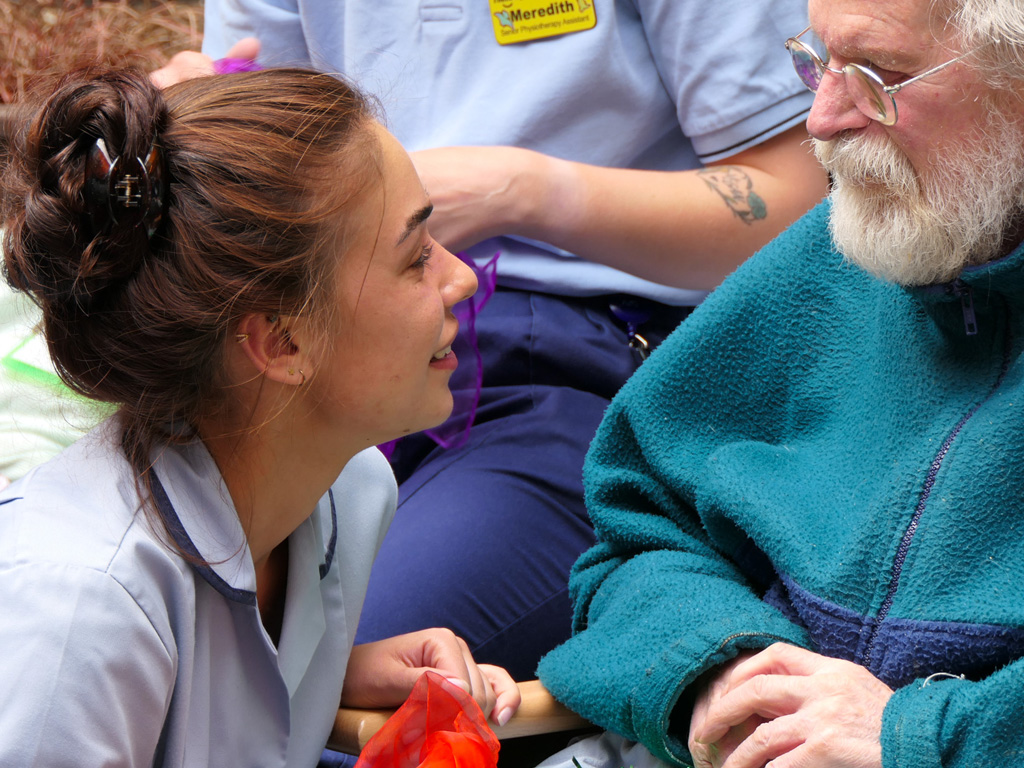 Photograph of young physiotherapy assistant talking to a patient.