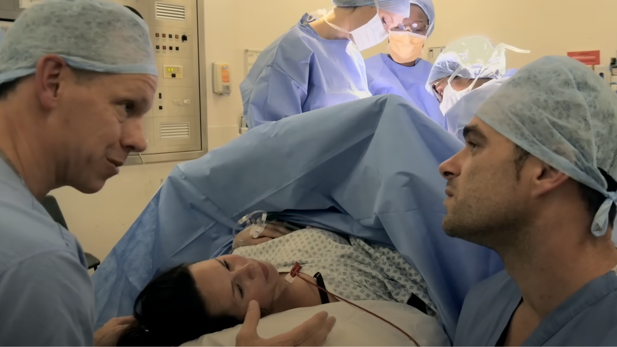 An operating theatre with surgeons discussing a caesarean section