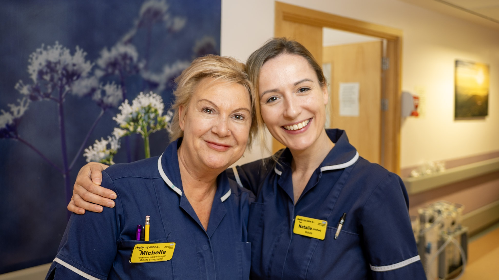 Two midwives stood in the hospital corridor