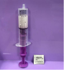 Syringe shown with solution inside, tip upright and air removed (also shows blister pack)