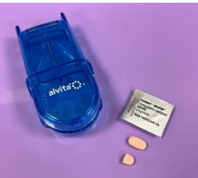 Tray with equipment to administer pills including the pills, blister pack and pillcutter, the pill is shown whole and halved