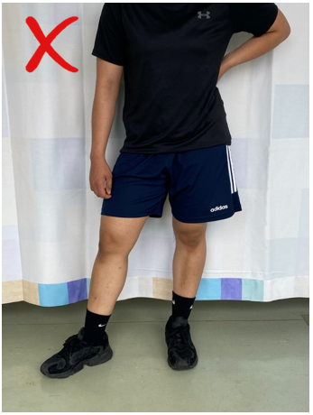 A do not image with a red cross of an individual stood with weight evenly distributed on both feet