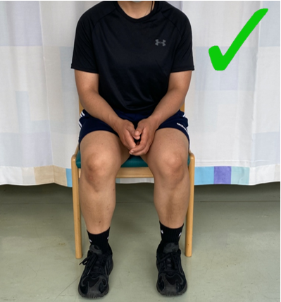A do image with a green tick showing an individual sat with feet, knees and hips aligned