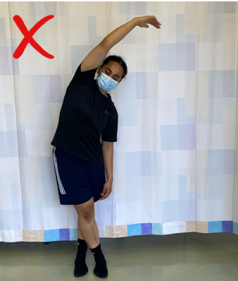 A do not image with a red cross showing an individual stretching arm up and overhead with legs crossed 
