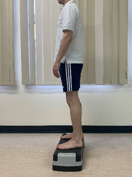 Image shows an individual with both feet flat on raised step