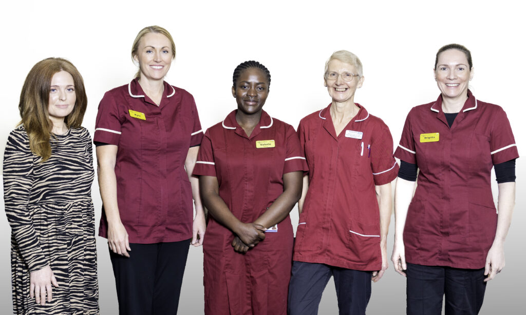 Five staff members from the Weight Management team stand side by side indoors against a plain background. Four individuals are wearing matching burgundy clinical uniforms with name badges, and one person at the far left is wearing a patterned dress.