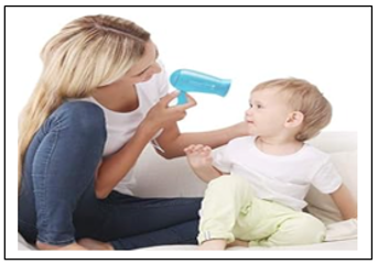 A photograph of a lady holding a hairdryer near the child's hair
