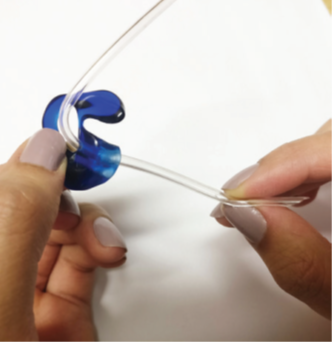 A photograph of the person using their fingers to pull the tube through till the bend reaches the mould