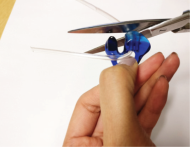 A photograph of the person using scissors to cut the tapered end off as close to the mould as possible