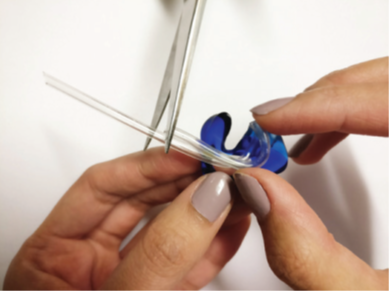 A photograph of the person using the old tube to measure the length of the new tube. Cut where appropriate
