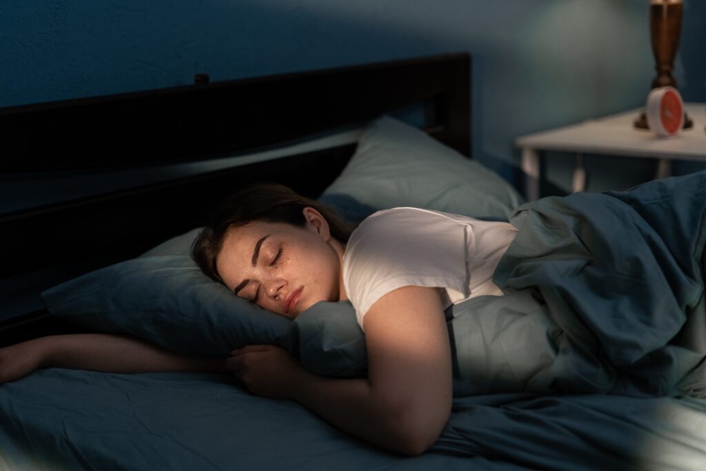 A woman sleeping peacefully in her bedroom at night. 